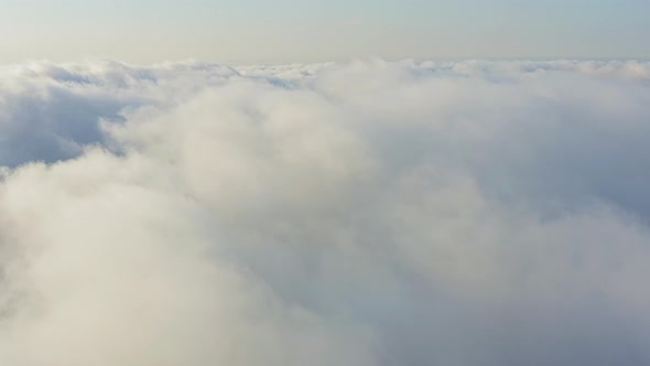 The Drone Rises From the Thick Fog Over the Beautiful Ocean of Clouds at Dawn