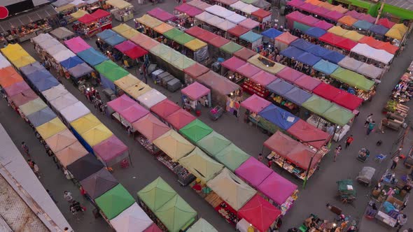 Time lapse of aerial top view of Night Market people walking street, Colorful tents