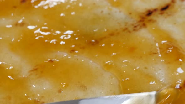 Jam of peaches spreading over pancake texture close-up 4K 2160p 30fps UltraHD tilting footage - Knif