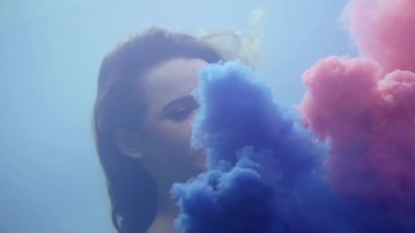 Dream and Fantasy Young Woman is Swimming Underwater Clouds of Blue and Pink Paints are Swaying