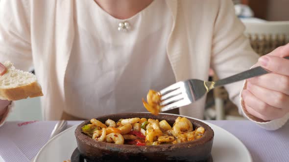 Unrecognizable Woman is Eating Frying Hot Shrimps with Vegetables Served in Clay Bowl Closeup Dish