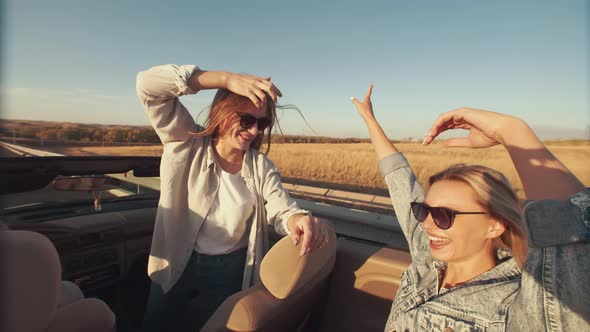 Lifestyle Fun in Trip Beautiful Women in Sunglasses Sit on Front and Back Seat of Cabriolet