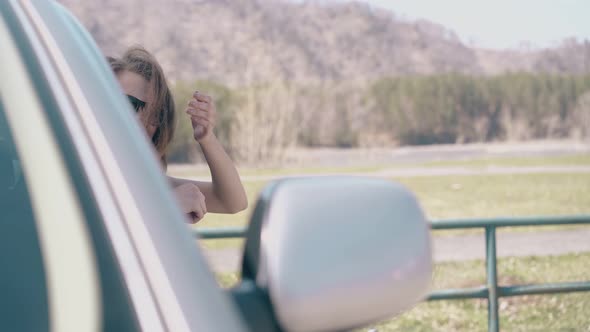 Cheerful Girl Talks with Friend in Car at Rural Site Closeup