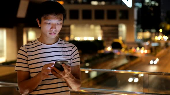 Young man using smart phone in city