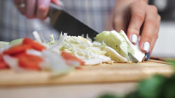 Extreme Closeup Female Chef Slicing Organic Cabbage with Sharp Knife