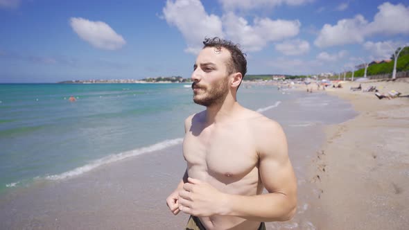 Young man jogging on the beach.