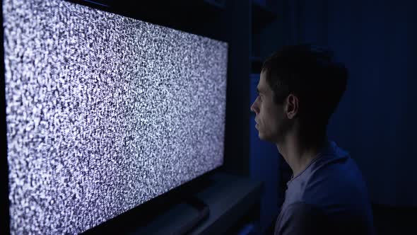A Man Watching TV Channel with Grain