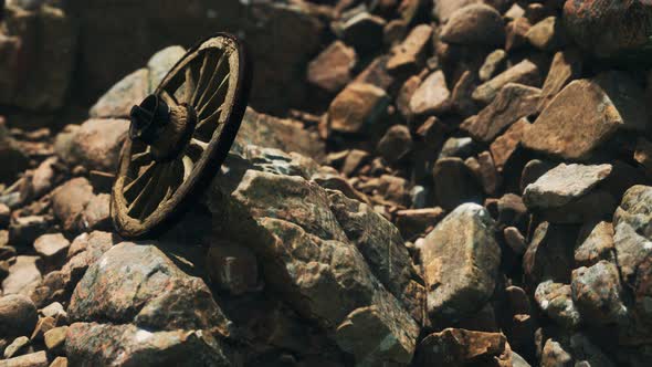 Old Wooden Wheel on Rocks alt