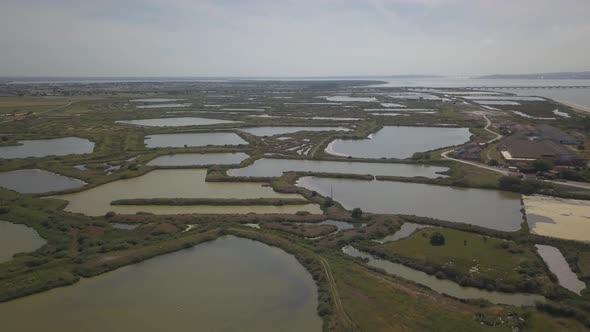 aerial view of Samouco Salt Flats in Alcochete with river and vasco da gama in background, Portugal.