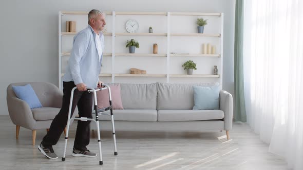 Impaired Mature Male Walking With Disability Frame At Home
