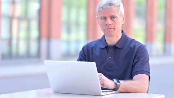 Outdoor Middle Aged Businessman Smiling at Camera While Using Laptop