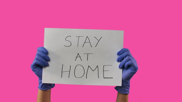 Hands Girl in Medical Gloves Holds a Sheet of Paper on Which Is Written Stay at Home