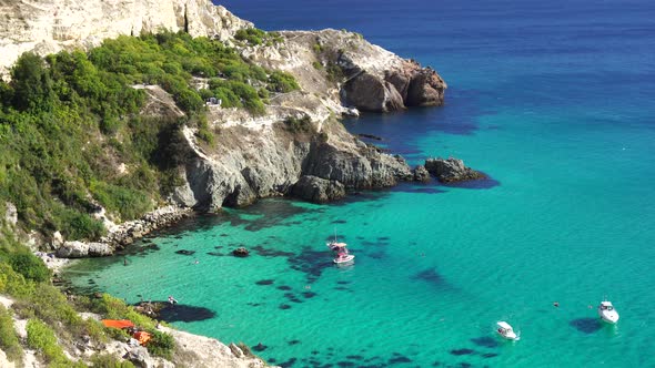 Boats and Yachts in the Rocky Bay with Crystal Clear Azure Sea on a Sunny Day