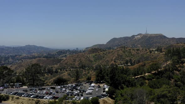 Aerial video of a parking lot in the mountains of Los Angeles with the hollywood sign in the distanc