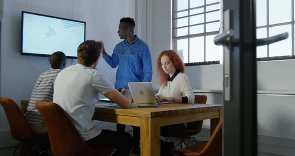 Young mixed-race business team planning and working in meeting room of modern office 4k