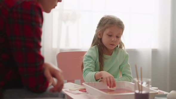 Little Girl Colors Eggs with Ebru Decor Near Sister at Home