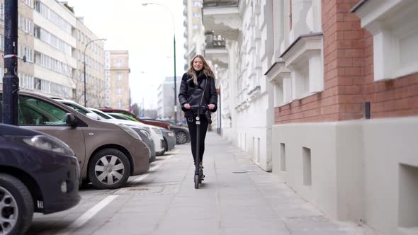 Trendy Female Riding Electric Scooter on Street