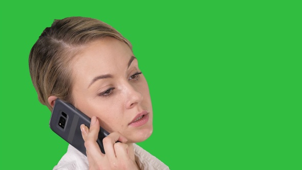 Woman with blonde hair talking on cellphone on a Green