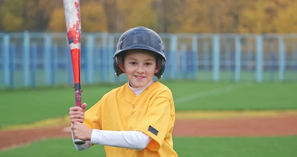 Portrait of a Boy Baseball Player on a Blurry Background Batter Holds a Baseball Bat in His Hands