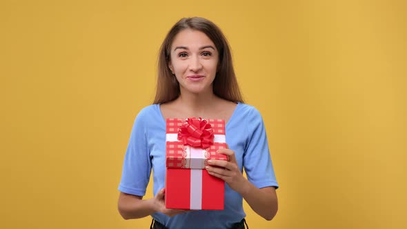 Portrait of Surprised Woman Opening Red Festive Gift Box with Bow Desired Present Posing Isolated