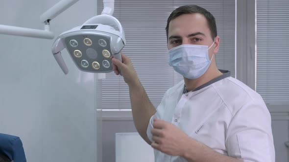 Portrait of a Male Dentist Taking Off His Protective Mask and Smiling