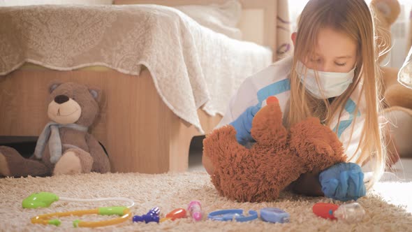 Beautiful Little Girl Playing Doctor with Teddy Bear at Home