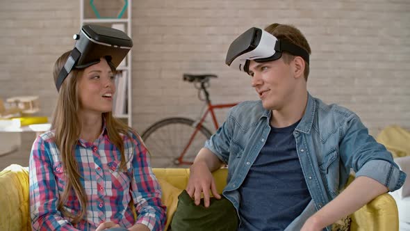 Young Woman and Man with VR Goggles Chatting