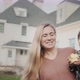Portrait of a Happy Mother with a Baby in Her Arms Against the Background of a Large House - VideoHive Item for Sale