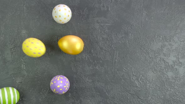 Easter Colourful Eggs Rolling on a Dark Concrete Table