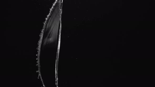 Water splash in midair against black background. Slow Motion. Unedited version included.