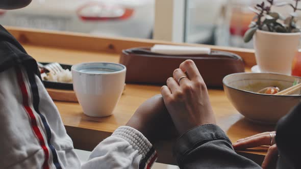 Female Couple Holding Hands in Cafe