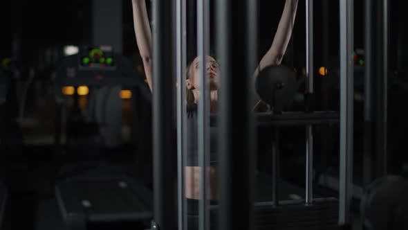 Female in the Gym Lifting Blocks on Rack Machine Training on Block Device and Gym Equipment Night