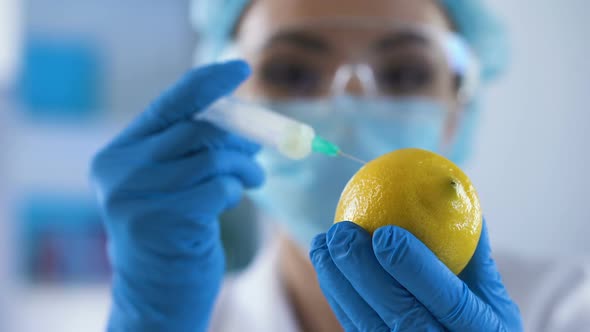 Female Researcher Injecting Test Liquid Lemon Sample, Toxicology Experiment