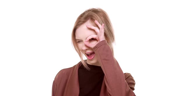 Young Playful Teenager Caucasian Girl Winking at Camera and Showing Ok