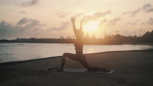 Silhouette of Woman Practices Yoga and Doing Stretching at Sunrise Slow Motion