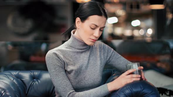 Unhappy Woman Worried About Treason Drinking Alcohol at Bar