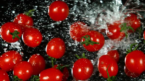 Super Slow Motion Shot of Flying Fresh Tomatoes and Water Side Splash at 1000Fps.