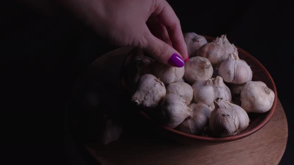 Pile of Whole Bulbs of Garlic in Ceramic Bowl on Table