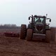 Modern tractor plows a field, moving for the camera. - VideoHive Item for Sale