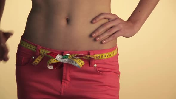 Woman measuring waist with tape and walking away