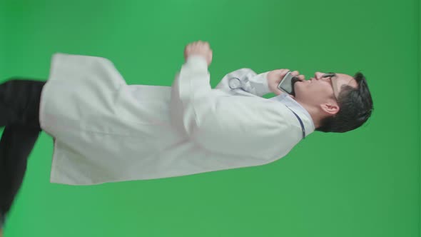 The Side View Of Asian Doctor With Stethoscope Talking On Mobile Phone While Running On Green Screen