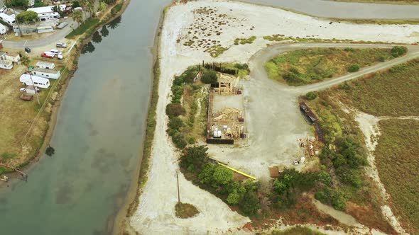 A rotating aerial view of a set of waterfront oil pumpjacks.