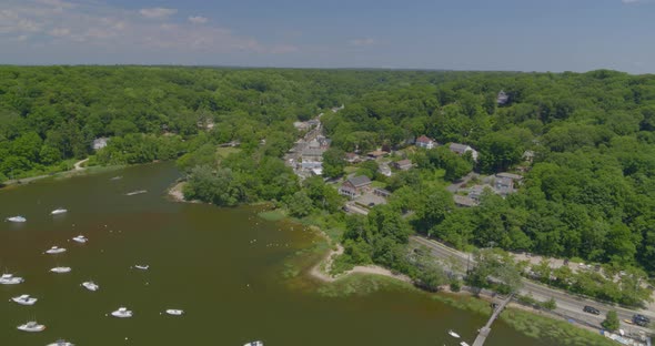 Aerial Pan from Boats Anchored on Harbor to a Small Town Amongst Trees