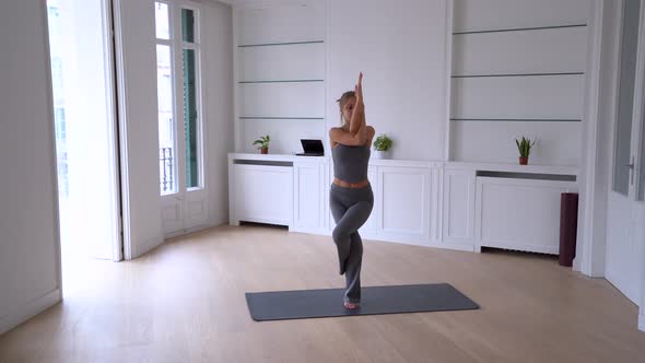 Flexible woman practicing yoga at home