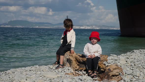 Two Boys Children in Fashionable Clothes Walk on the Stone Sea Beach