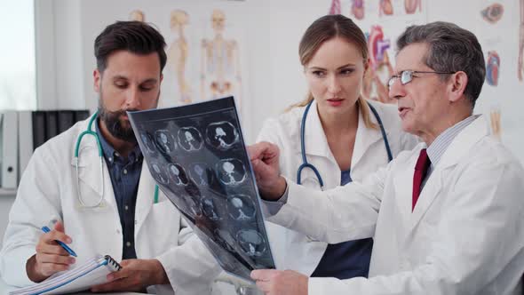 Handheld view of doctors examining the medical record. Shot with RED helium camera in 8K