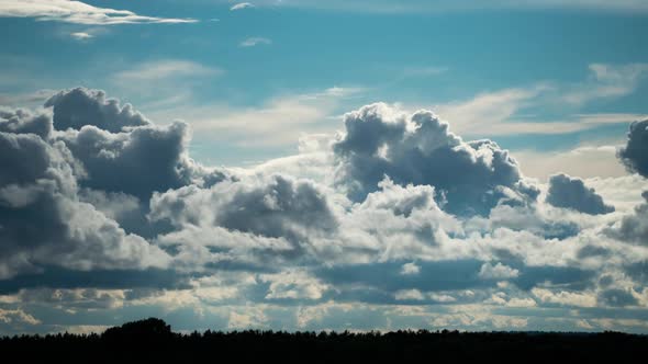 White Fluffy Clouds Slowly Float Through the Blue Daytime Sky Timelapse