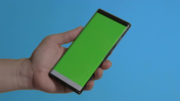 Smartphone screen. Smart phone isolated on color background. Green screen chroma key technique. Man