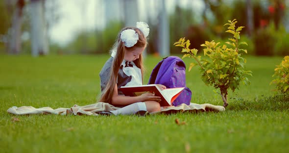 School Girl Reading Book on Lawn