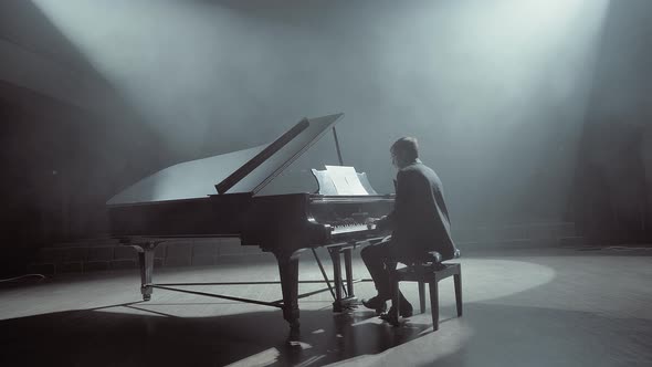 Pianist in Dark Suit Playing on a Grand Piano on Big Stage